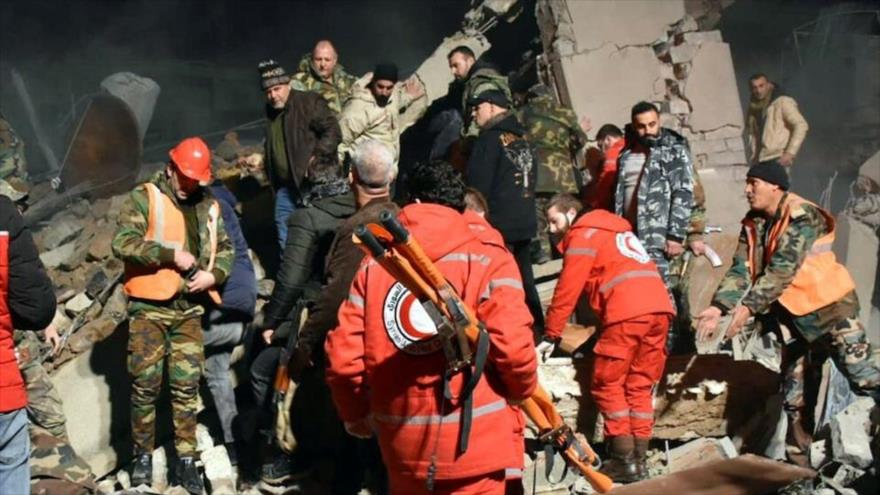 Los equipos de rescate buscan sobrevivientes bajo los escombros de un edificio destruido en un ataque israelí en la provincia siria de Homs, 7 de febrero de 2024.
