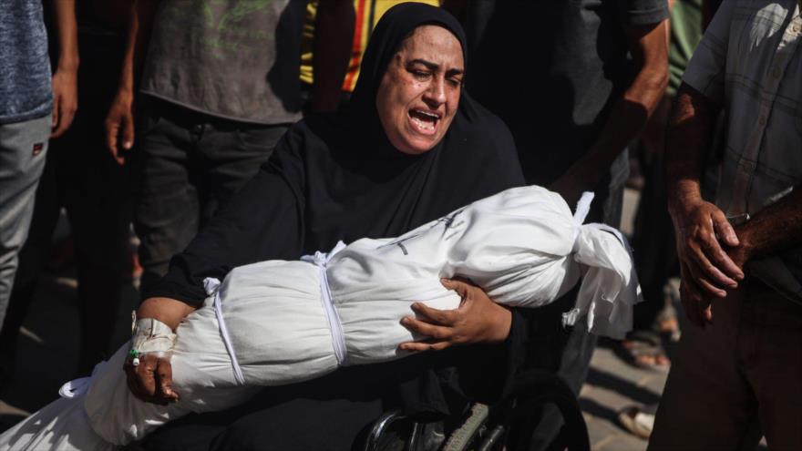 Mujer palestina llora mientras sostiene el cuerpo de un niño muerto en ataques israelíes en Deir al-Balah, en la Franja de Gaza, 25 de junio de 2024.