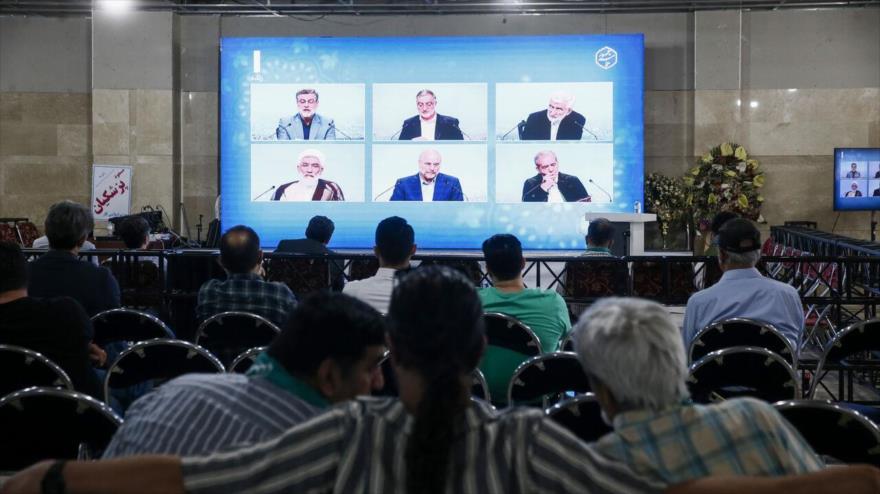 La gente ve en una pantalla el último debate televisivo de los candidatos para las elecciones presidenciales de Irán, 25 de junio de 2024.