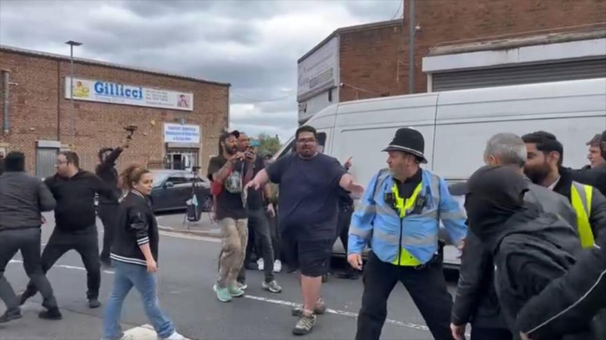 Policiales se enfrentan en el Reino Unido con las personas que intentan interrumpir el proceso de las presidenciales de Irán en este país, 28 de junio de 2024.