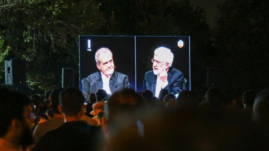 La gente observa el último debate entre los candidatos a la Presidencia de Irán en un parque en Teherán, 2 de julio de 2024.