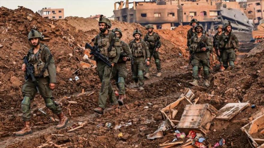  Soldados israelíes pasando por las ruinas de la ciudad Rafah.