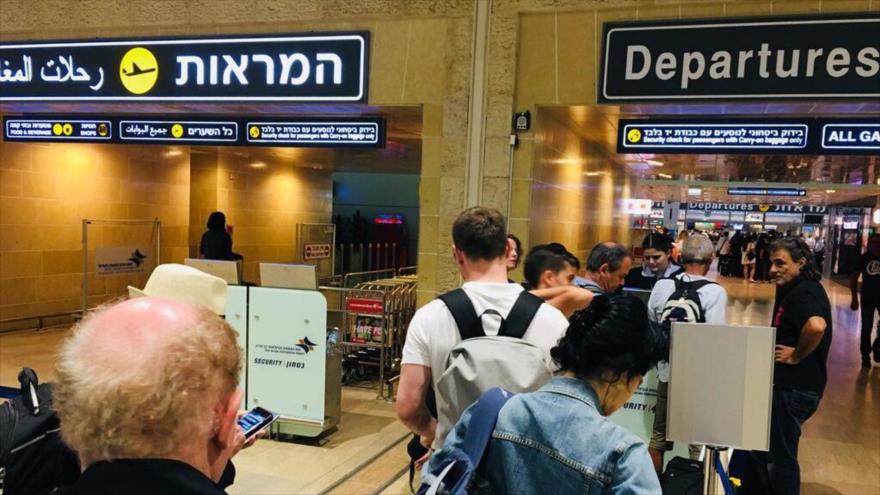 Colonos israelíes esperan la partida de sus vuelos en el aeropuerto Ben Gurión de Israel.