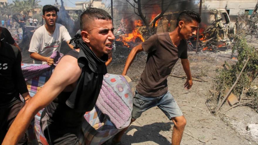 Los palestinos llevan a las víctimas del ataque israelí en el campo de refugiados de Al-Mawasi en el sur de Gaza, 13 de julio de 2024.