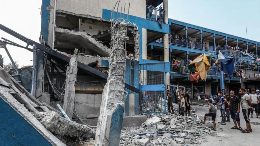 Palestinos y trabajadores de la ONU examinan tiendas de campaña y refugios improvisados destruidos tras el ataque israelí en Al-Nuseirat, 15 de julio de 2024.