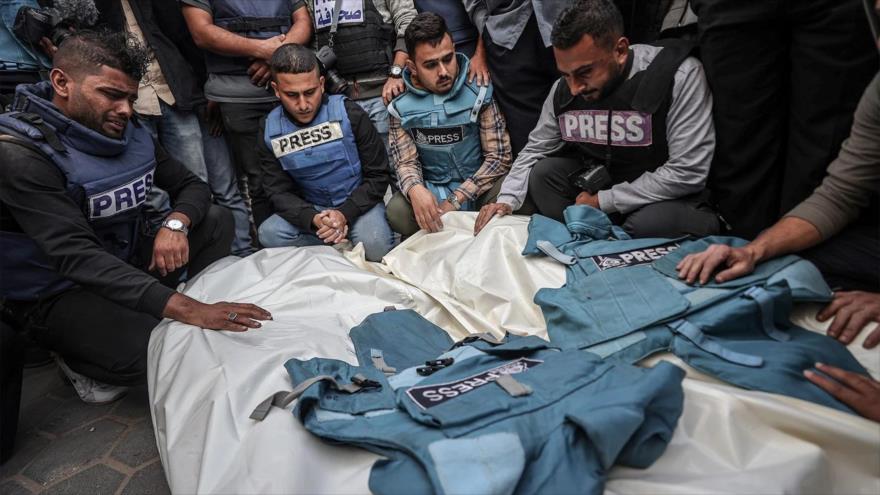 Familiares y colegas de los periodistas palestinos Sari Mansur y Hasona Saliem, asesinados en ataques israelíes, durante una ceremonia fúnebre en Gaza, 19 de noviembre de 2023.