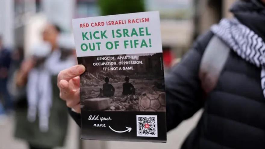 Manifestante propalestino mantiene un panfleto con la leyenda “Expulsen a Israel de la FIFA”. (Foto: Reuters)