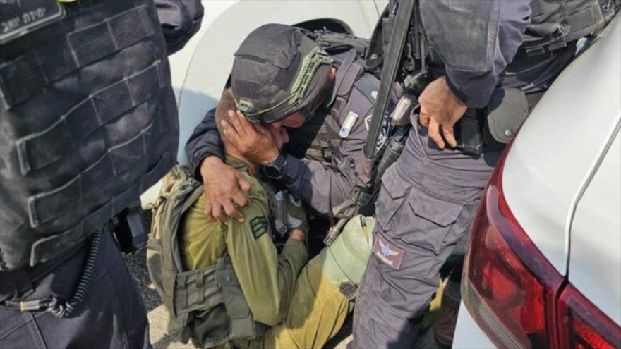 Un militar israelí consolando a un soldado en el asentamiento ilegal de Kfar Aza tras la potente operación de HAMAS, 7 de octubre de 2023.