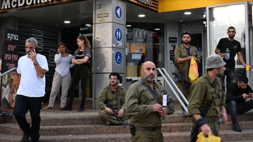 Soldados y civiles israelíes en una gasolinera cerca de la ciudad de Sderot en los territorios ocupados.