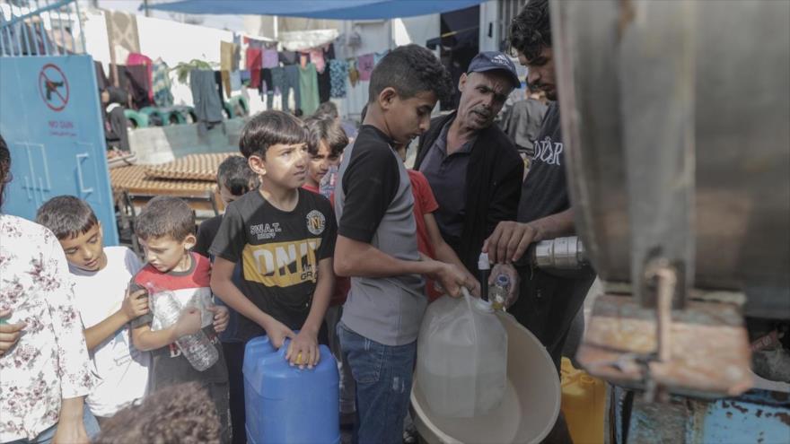 Residentes del campamento de Jan Yunis hacen cola para llenar contenedores de agua de un camión cisterna en el sur de la ciudad de Gaz, 22 de octubre de 2023. (Foto: EFE)