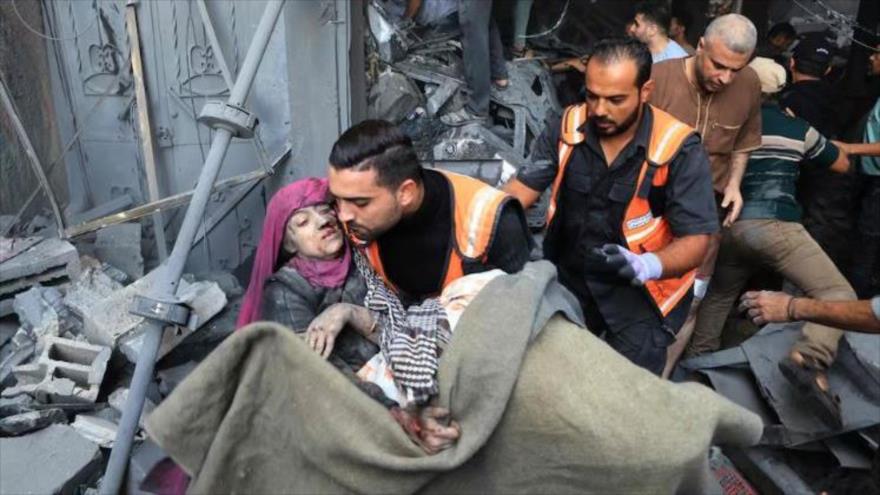Un hombre carga con una persona herida tras un bombardeo israelí en Jan Yunis, en el sur de la franja de Gaza. (Foto: AFP)