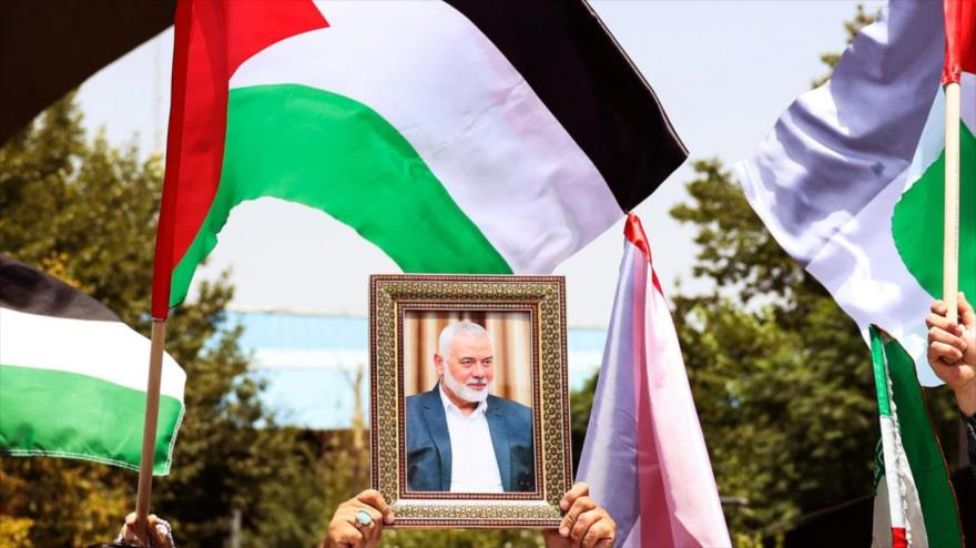 La gente sostiene la bandera palestina y un retrato del asesinado jefe de HAMAS, Ismail Haniya, durante una manifestación en Teherán, 31 de julio de 2024. (Foto: AFP)