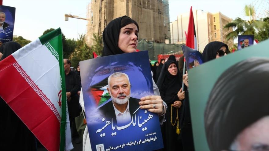 Iraníes portan imágenes del líder de HAMAS, Ismail Haniya, durante una ceremonia funeraria en Teherán, 1 de agosto de 2024.