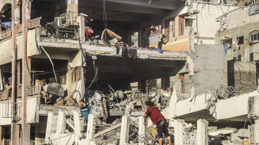 Palestinos inspeccionan una escuela atacada por aviones de guerra israelíes en el norte de la ciudad de Gaza, 3 de agosto de 2024.