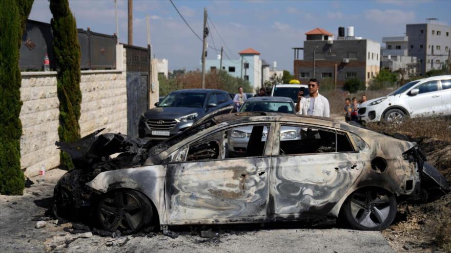 Palestinos revisan vehículos quemados después del ataque de colonos israelíes en Cisjordania ocupada por Israel, 16 de agosto de 2024.