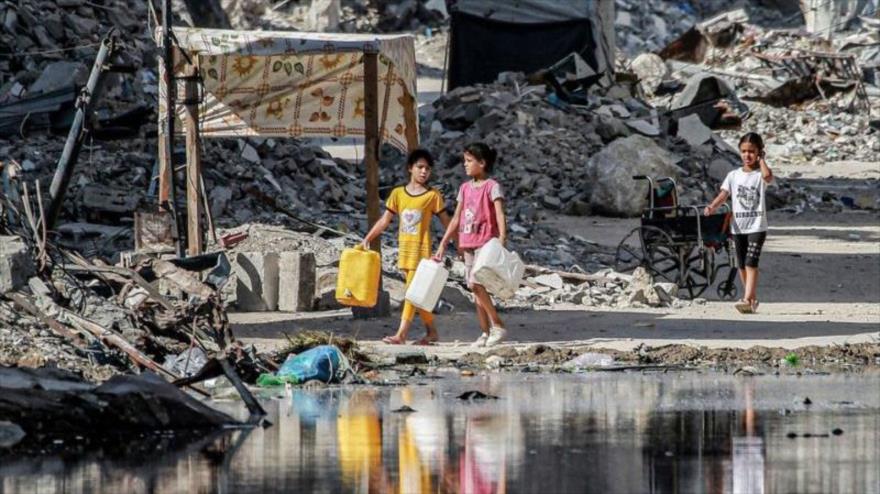 Unas niñas gazatíes en busca de agua entre las ruinas perpetradas por Israel en Gaza.