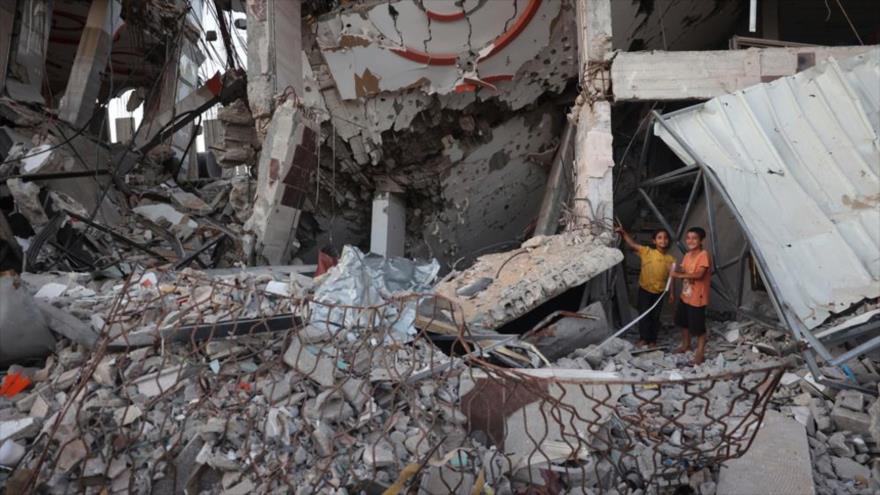 Niños juegan sobre los escombros de un edificio destruido en el campo de refugiados de Al-Bureij, en el centro de Gaza, 26 de junio de 2024. (Foto: AFP)