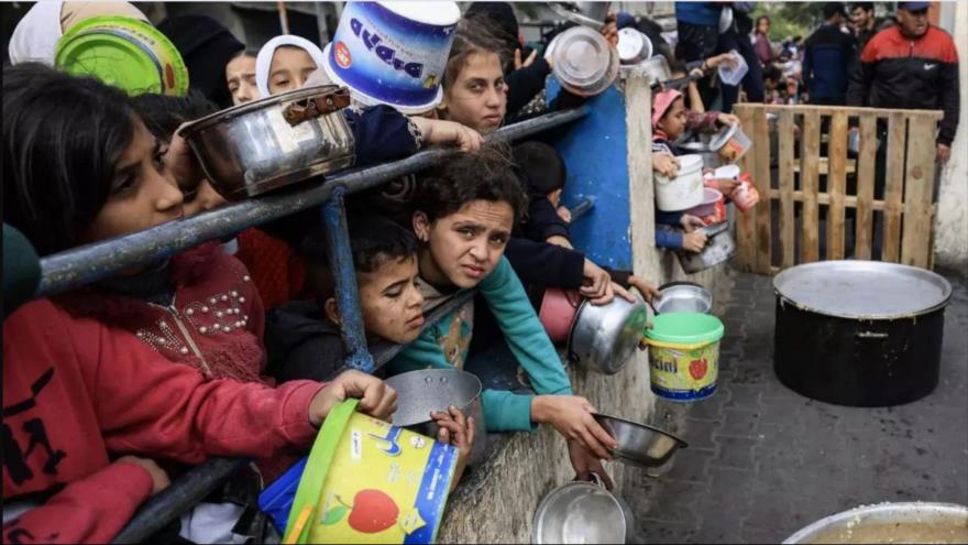 Un grupo de niños palestinos espera el reparto de comida en un campo de refugiados, Rafah. (Foto: AFP)