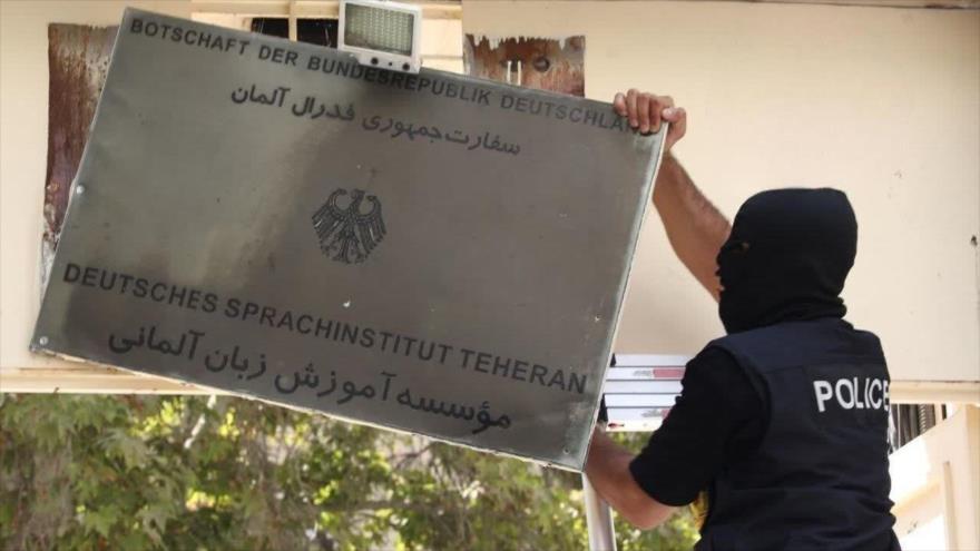 Un agente de la policía iraní retira el cartel de una sucursal del Instituto de Lengua Alemana de Teherán, en la capital de Irán. (Foto: Tehran Times)
 