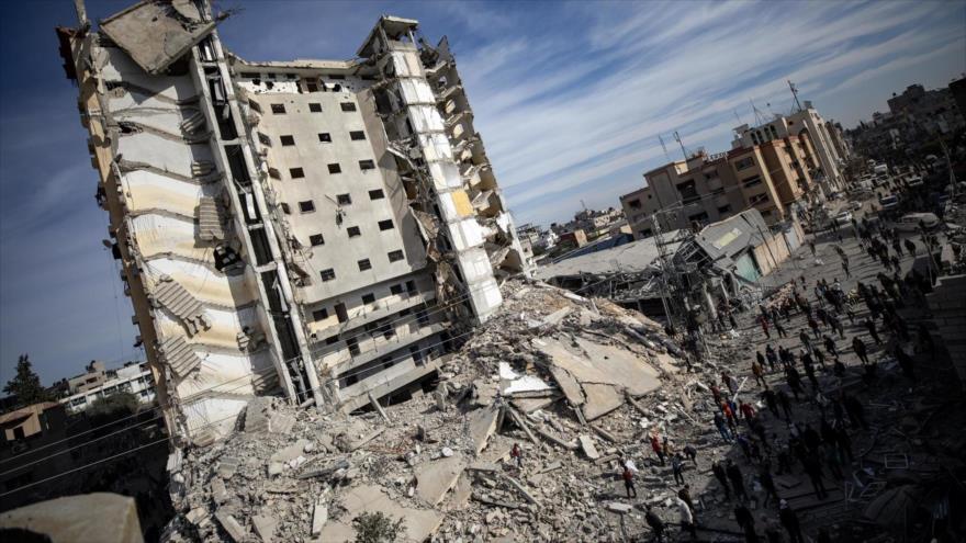 Palestinos inspeccionan zona tras ataque aéreo israelí que alcanzó Torre Al-Masry en campo de refugiados de Rafah, en sur de Gaza, 9 de marzo de 2024.