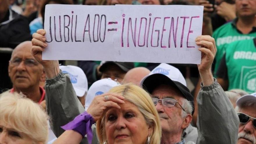 Un jubilado argentino lleva una pancarta en la que se ha escrito: jubilado es igual que indignado.