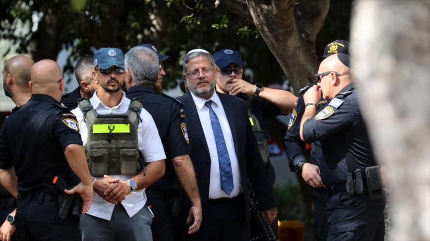 El ministro de Seguridad de Israel, Itamar Ben Gvir, flanqueado por guardaespaldas y agentes de policía, en un suburbio de Tel Aviv, 4 de agosto de 2024.