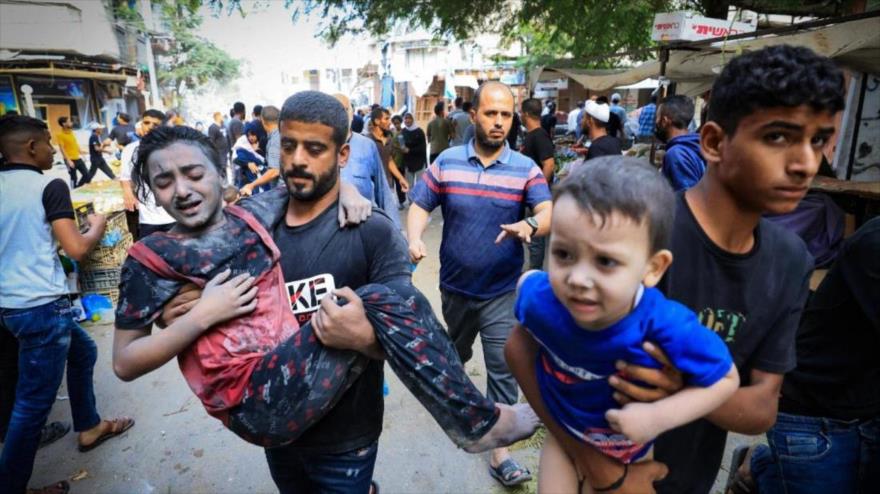 Un hombre se lleva a una niña herida tras un ataque israelí contra el campo de refugiados de Bureij, en el centro de la Franja de Gaza, el 2 de noviembre de 2023 (foto: AFP)