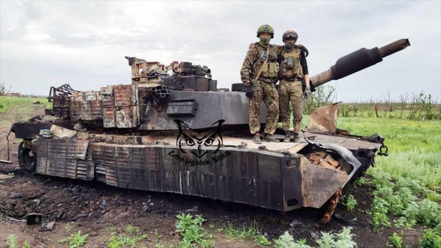 Soldados rusos posando sobre un tanque estadounidense Abrams destruido en Ucrania.