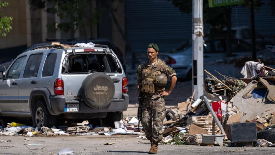 Un soldado libanés camina entre coches dañados y escombros tras un ataque aéreo israelí en Beirut, 30 de septiembre de 2024.