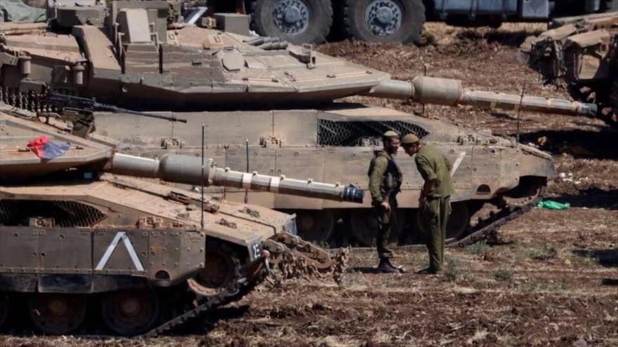 Militares israelís se encuentran junto a vehículos blindados en el norte de Palestina ocupada, 30 de septiembre de 2024. (Foto: Reuters)