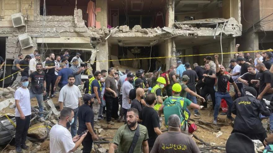 Civiles se reúnen cerca de un edificio dañado en un ataque con misiles israelí en un suburbio del sur de Beirut (Líbano), 20 de septiembre de 2024. (Foto: AP)