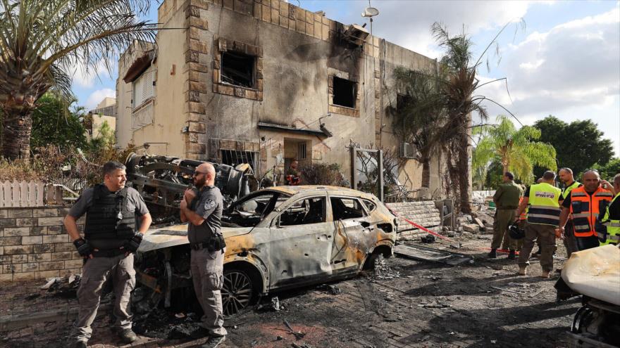 Equipos de emergencia y fuerzas de seguridad se reúnen entre escombros y vehículos calcinados en Kiryat Bialik, en Haifa, tras un ataque con cohetes de Hezbolá, 22 de septiembre de 2024.