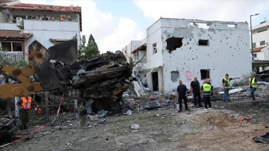 Una excavadora retira un coche calcinado en Kiryat Bialik, en el distrito de Haifa, tras un ataque de Hezbolá. (Foto: AFP)