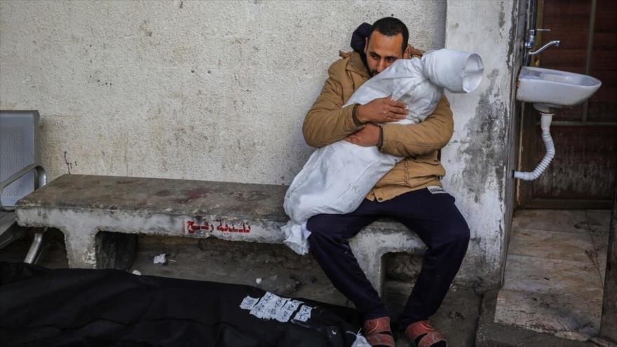 Un hombre abraza el cadáver de un menor víctima de un ataque israelí sobre la ciudad de Rafah, en Gaza.