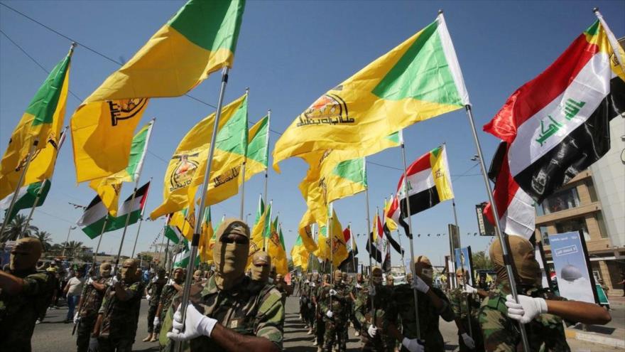 Combatientes de la Resistencia iraquí Kataib Hezbolá realizan un desfile militar con banderas del movimiento y las banderas nacionales de Irak. (Foto: archivo)