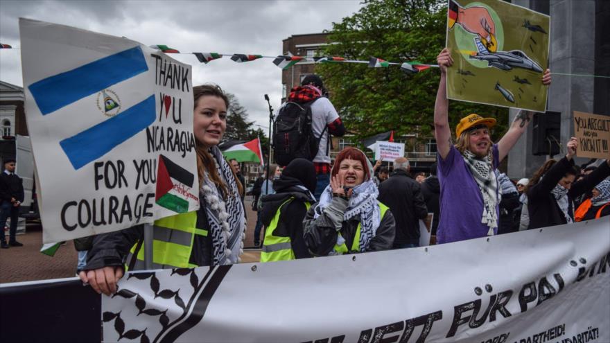 Manifestantes pro-Palestina sostienen pancartas con banderas de Palestina y de Nicaragua frente a la CIJ en La Haya (Países Bajos), 9 de abril de 2024.