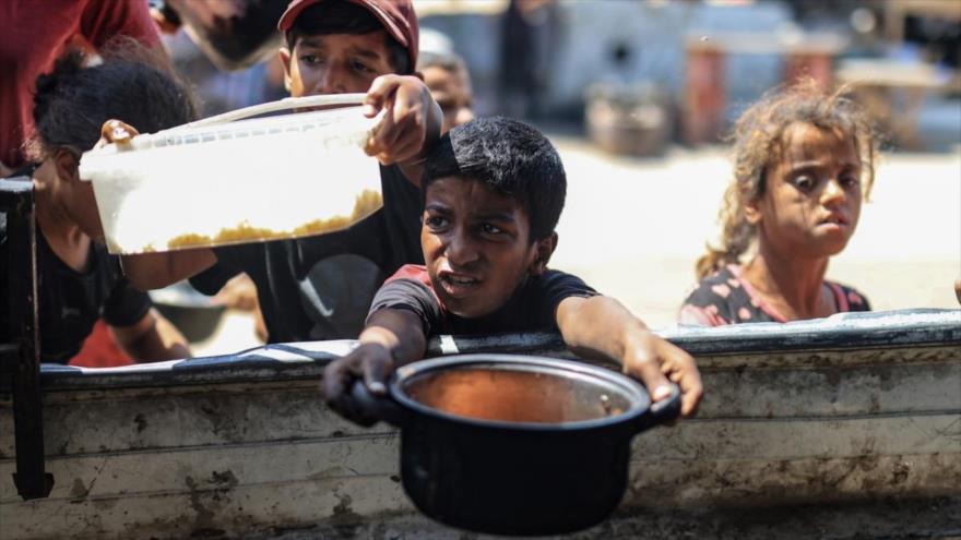 Palestinos aguardan su turno para la comida en Jan Yunis. (Foto: EP)