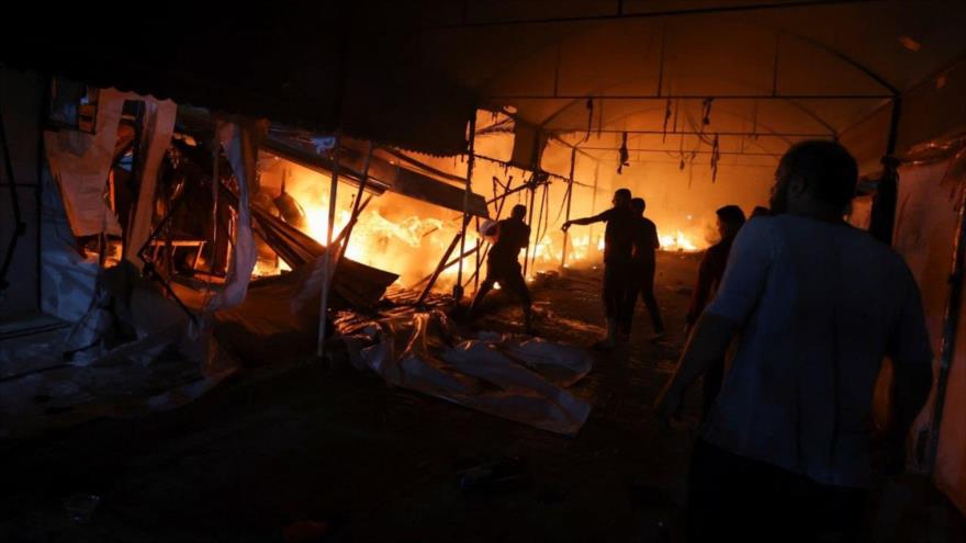 Palestinos intentan apagar un incendio en el lugar de un ataque israelí a tiendas de campaña en el hospital de Mártires de Al-Aqsa, en Gaza, 14 de octubre de 2024. (Foto: Reuters)