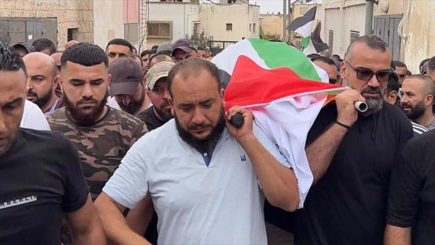 El cuerpo de Hanan Abu Salami es llevado durante los procedimientos funerarios en Faqoua, 17 de octubre de 2024.