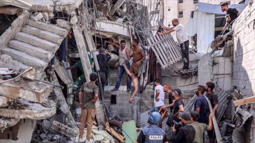 Personas se reúnen frente a edificio derrumbado tras un bombardeo israelí en el distrito de Saftawi en Jabalia, en el norte de la Franja de Gaza (foto: AFP)