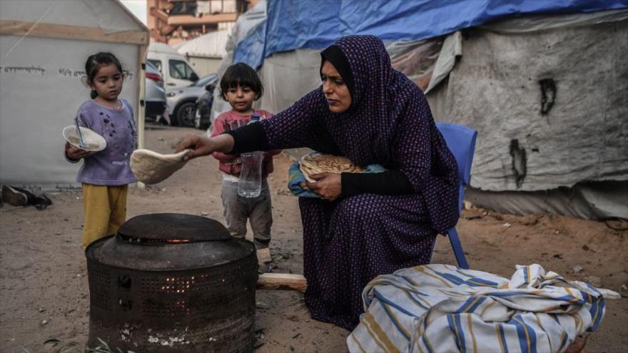 Una madre prepara comida para sus hijos en casa improvisada en un campo de refugiados de Jan Yunis, Gaza (foto: ONU)