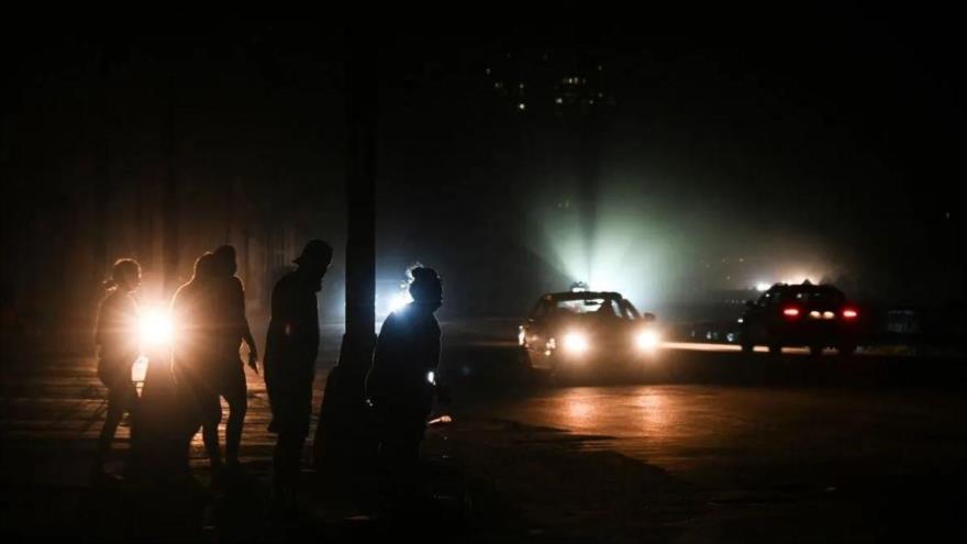 Cubanos caminan por una calle durante la tercera noche de un apagón nacional en La Habana, 20 de octubre de 2024. (Foto: AFP)