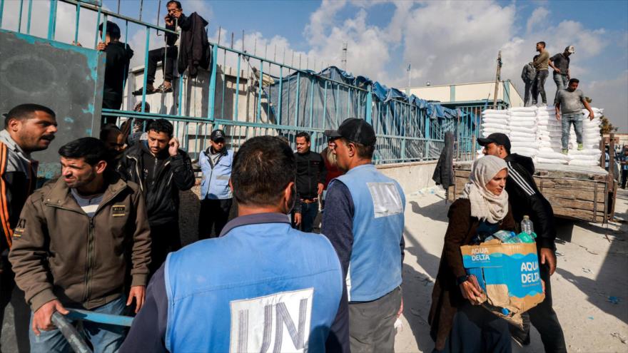 Trabajadores de la UNRWA entregan raciones de harina y otros suministros a las en Gaza, 12 de diciembre de 2023. (Foto: AFP)