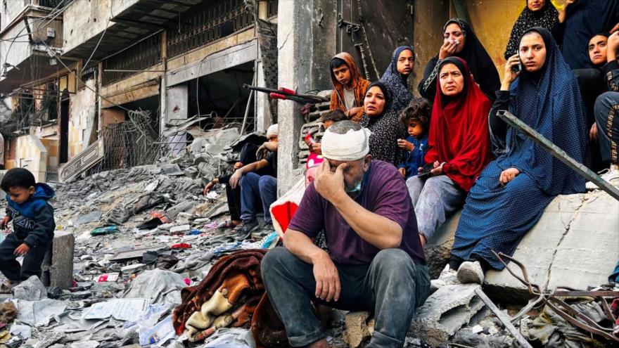 Palestinos, sentados sobre los escombros de un edificio alcanzado por un ataque israelí en Beit Lahia, en el norte de Gaza, 29 de octubre de 2024. (Foto: AFP)