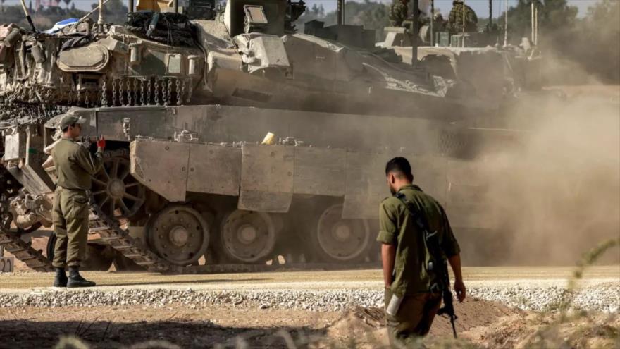 Un soldado israelí pasa junto a un tanque en una posición cerca de la frontera con la Franja de Gaza, 30 de abril de 2024 (Foto: AFP)