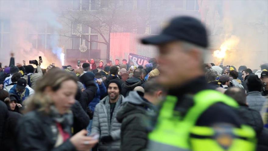 Fanáticos del Maccabi Tel Aviv israelí se manifiestan y encienden bengalas mientras un policía patrulla la zona en Ámsterdam, Países Bajos, 7 de noviembre de 2024. (Foto: Reuters)