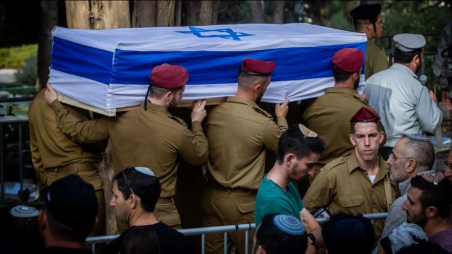 Militares israelíes sostienen el ataúd de un colega muerto en los combates.
