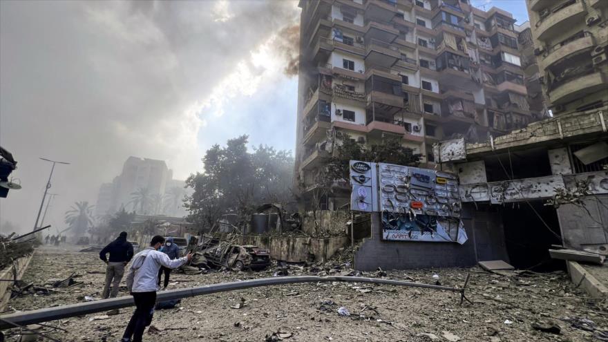 Unos hombres vigilan la destrucción en el lugar de un ataque aéreo israelí contra un barrio del sur de Beirut, 13 de noviembre de 2024. (Foto: AFP)