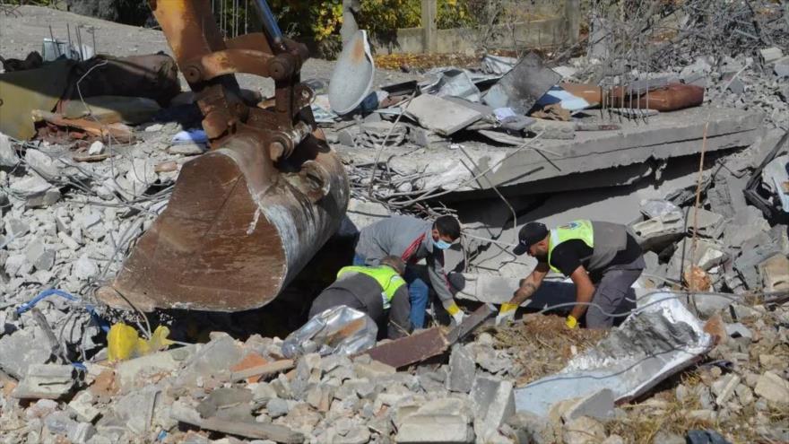 Miembros de la Defensa Civil libanesa retiran escombros de una vivienda derrumbada en un ataque israelí en Baalbek.