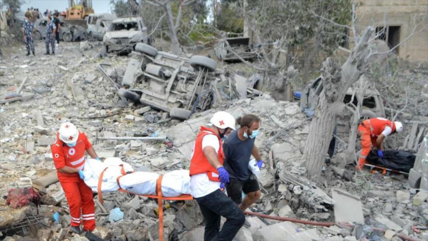 Socorristas de la Cruz Roja libanesa sacan un cadáver de entre los escombros en el lugar donde se produjo un ataque aéreo israelí contra la aldea de Aito, en el norte del Líbano, 14 de octubre de 2024. (Foto: AFP)
